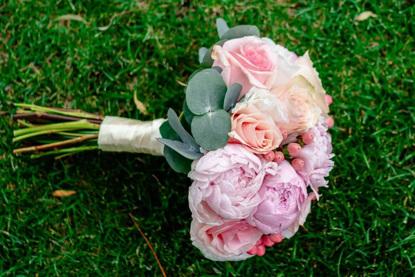 Agradável e bonito buquê de casamento de flores na grama verde — Fotografia de Stock