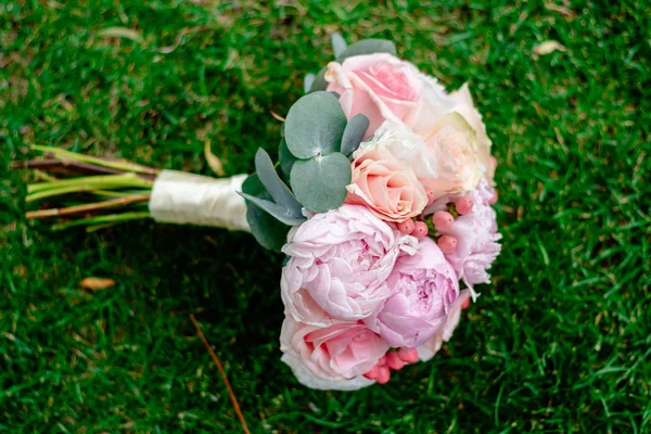 Agradável e bonito buquê de casamento de flores na grama verde — Fotografia de Stock