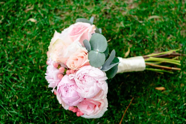 Szép és szép esküvői csokor virágot a zöld fű — Stock Fotó