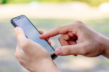 genç adam yeşil bir arka plan yakın elinde bir telefon tutar