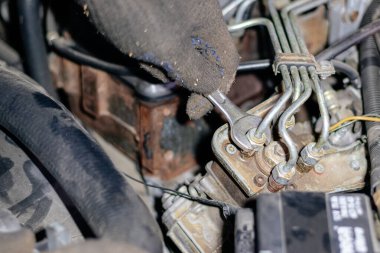 Tamirci adam garajda çalışıyor. Eski bir c 'nin motorunu tamir eder