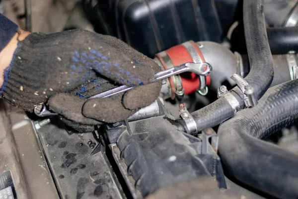 Man mechanic works in the garage. Repairs the engine of an old c — Stock Photo, Image