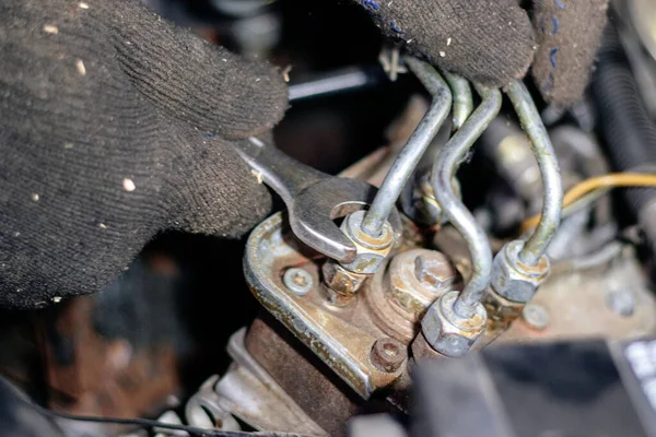 De monteur werkt in de garage. Repareert de motor van een oude c — Stockfoto