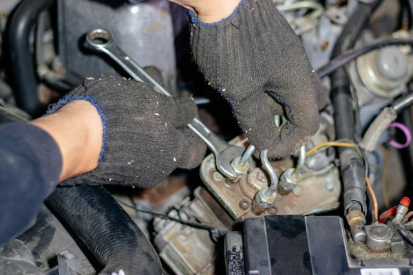 O mecânico trabalha na garagem. Repara o motor de um velho c Imagens De Bancos De Imagens