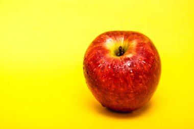 Büyük kırmızı elma ile sarı arka plan, fotoğraf reklam için mükemmel. Apple sağlıklı bir meyvedir.