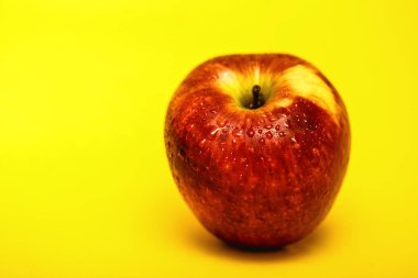 Büyük kırmızı elma ile sarı arka plan, fotoğraf reklam için mükemmel. Apple sağlıklı bir meyvedir.