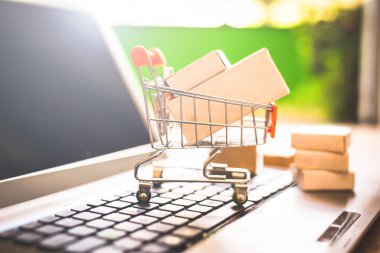 Laptop klavye üzerinde bir alışveriş sepeti kutularında. Konsept alışveriş ve online satış hakkında. Doğrudan Internet'ten, ev konforunda mal satın.