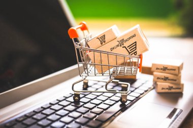 Laptop klavye üzerinde bir alışveriş sepeti kutularında. Konsept alışveriş ve online satış hakkında. Doğrudan Internet'ten, ev konforunda mal satın.