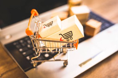 Laptop klavye üzerinde bir alışveriş sepeti kutularında. Konsept alışveriş ve online satış hakkında. Doğrudan Internet'ten, ev konforunda mal satın.