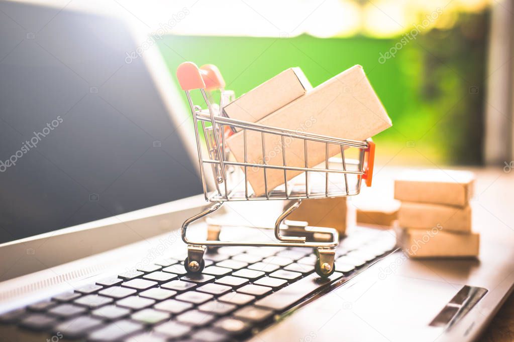 Boxes in a shopping cart over laptop keyboard.Concept about shopping and online sales. Buy your goods directly from the Internet, from the comfort of your home.