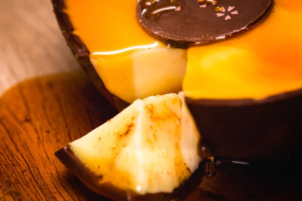 Détail d'un oeuf en chocolat coupé en tranches avec crème goutte à goutte . — Photo
