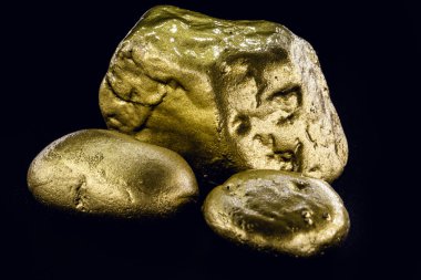 Altın külçesi, siyah arka plan üzerinde izole edilmiş büyük altın taş yakın çekim. Finans, lüks veya zenginlik kavramı.