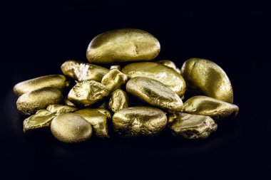 Altın külçesi, siyah arka plan üzerinde izole edilmiş büyük altın taş yakın çekim. Finans, lüks veya zenginlik kavramı.