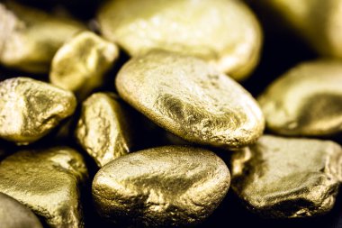 Altın külçesi, siyah arka plan üzerinde izole edilmiş büyük altın taş yakın çekim. Finans, lüks veya zenginlik kavramı.