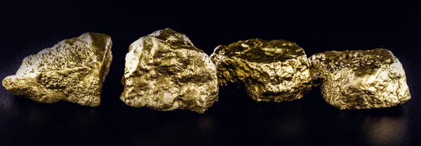 Pepita de oro, gran primer plano de piedra de oro aislado sobre fondo negro. Concepto de finanzas, lujo o riqueza . — Foto de Stock