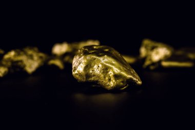 Golden stone in high resolution. Gold on black background isolated. Concept of luxury and wealth. clipart