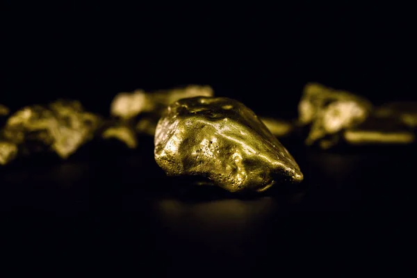 Piedra dorada en alta resolución. Oro sobre fondo negro aislado. Concepto de lujo y riqueza . — Foto de Stock