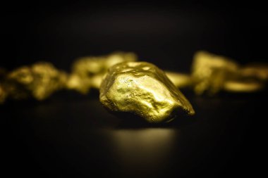 Golden stone in high resolution. Gold on black background isolated. Concept of luxury and wealth. clipart