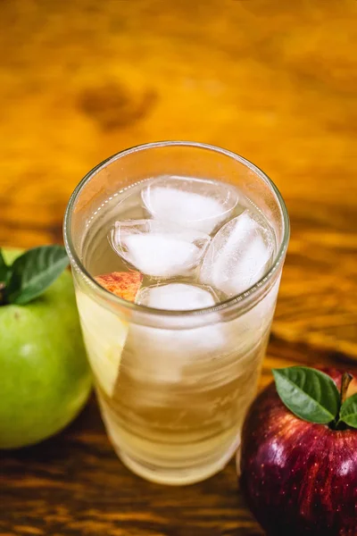 Lanzador de manzana spritzer (apfelschorle), jarra de vidrio de spritzer casero servido con hielo picado y rodajas de manzana. Jarra llena de zumo de manzana carbonatado frío y espumoso sin alcohol . — Foto de Stock