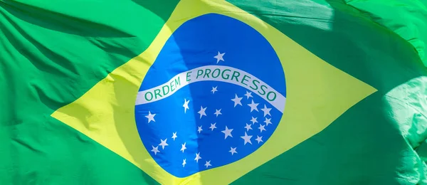 Brasil bandera nacional tela ondeando en la parte superior, cielo azul brasileño, concepto de patriotismo . — Foto de Stock