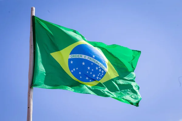 Brazil national flag textile cloth waving on top, blue sky brazil, patriotism concept.