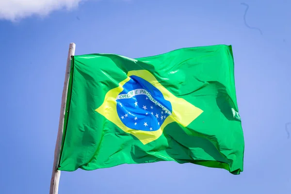 Brasil bandera nacional tela ondeando en la parte superior, cielo azul brasileño, concepto de patriotismo . — Foto de Stock