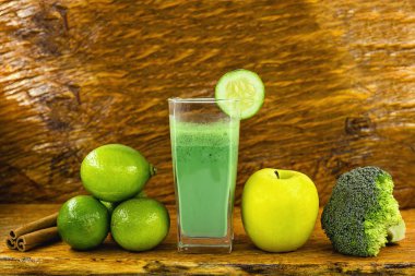Koyu ahşap arka plan üzerinde yeşil yüzlü. Sağlıklı smoothie bitkisel kokteyl. Yeşil meyve ve sebzeler. Sağlıklı gıda ve diyet konsepti.