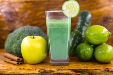 Koyu ahşap arka plan üzerinde yeşil yüzlü. Sağlıklı smoothie bitkisel kokteyl. Yeşil meyve ve sebzeler. Sağlıklı gıda ve diyet konsepti.