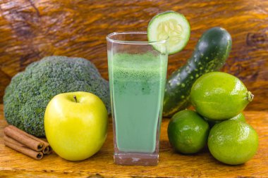 Koyu ahşap arka plan üzerinde yeşil yüzlü. Sağlıklı smoothie bitkisel kokteyl. Yeşil meyve ve sebzeler. Sağlıklı gıda ve diyet konsepti.