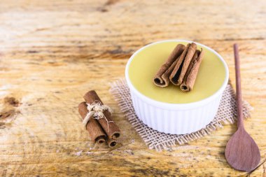 Brezilya tatlı mısır kremi tatlı, canjica veya Jimbel, tatlı bir ahşap arka plan tarçın ile mısır mısır mus tedavi. Kopyalama alanı