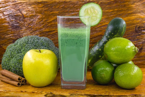 Koyu ahşap arka plan üzerinde yeşil yüzlü. Sağlıklı smoothie bitkisel kokteyl. Yeşil meyve ve sebzeler. Sağlıklı gıda ve diyet konsepti.