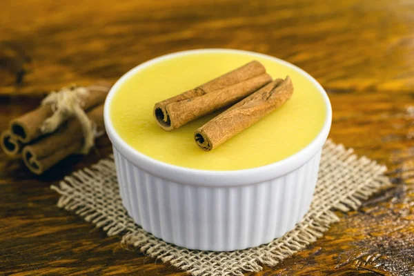 Sobremesa de creme doce brasileira mousse de milho curada com canela em um fundo de madeira rústico . — Fotografia de Stock