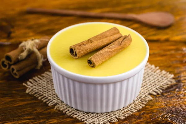 Бразильский сладкий кремовый десерт с кукурузным муссом с корицей на деревенском деревянном фоне . — стоковое фото