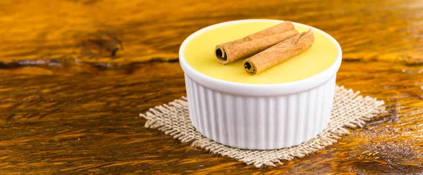 Sobremesa de creme doce brasileira mousse de milho curada com canela em um fundo de madeira rústico . — Fotografia de Stock