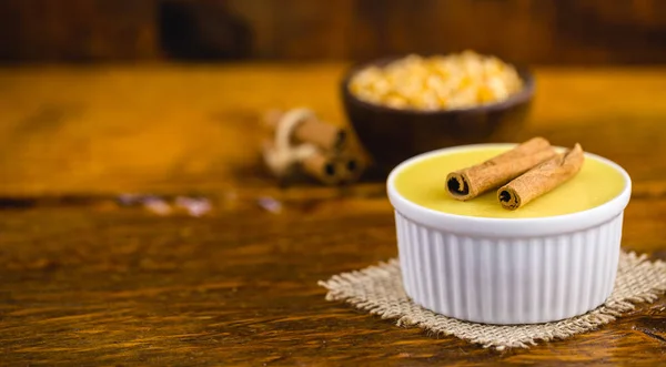 A sobremesa de creme doce brasileira curou a mousse de milho com canela em um fundo de madeira rústico. Cozinha brasileira típica doce em festas tradicionais, em um fundo de madeira com espaço de cópia . — Fotografia de Stock