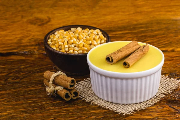 A sobremesa de creme doce brasileira curou a mousse de milho com canela em um fundo de madeira rústico. Cozinha brasileira típica doce em festas tradicionais, em um fundo de madeira com espaço de cópia . — Fotografia de Stock