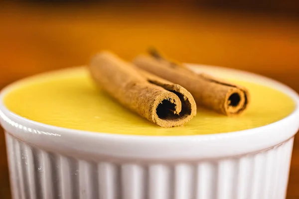 Typical Brazilian dessert, sweet of mingua, called in Brazil of curau. Typical sweet of June party. Brazilian sweet corn, corn mousse on a wooden background with copy space.