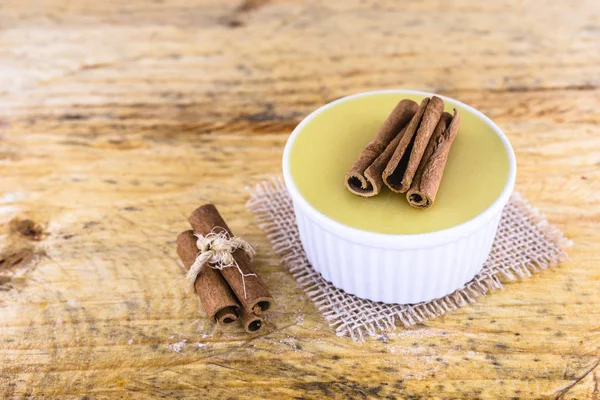 Brezilya tatlı mısır kremi tatlı, canjica veya Jimbel, tatlı bir ahşap arka plan tarçın ile mısır mısır mus tedavi. Kopyalama alanı