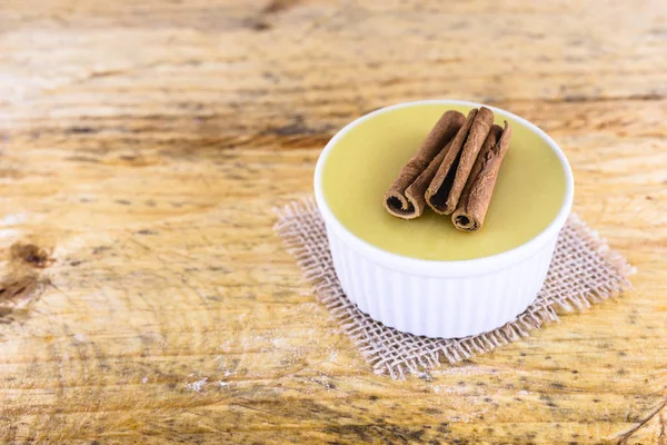 Brezilya tatlı mısır kremi tatlı, canjica veya Jimbel, tatlı bir ahşap arka plan tarçın ile mısır mısır mus tedavi. Kopyalama alanı