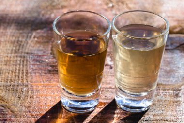 Brezilya altın ve beyaz cachaca rustik ahşap arka plan izole iki shot gözlük. Brezilya'dan tipik içecek.