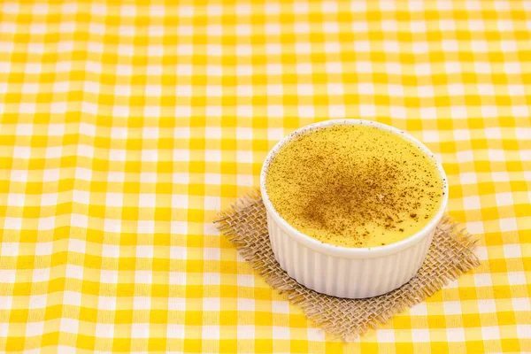 Brazilian sweet corn, corn mousse on a wooden background with copy space. Typical Brazilian dessert, sweet of mingua, called in Brazil of curau. Typical sweet of June party.