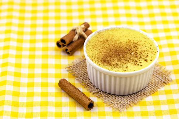 Brazilian sweet corn, corn mousse on a wooden background with copy space. Typical Brazilian dessert, sweet of mingua, called in Brazil of curau. Typical sweet of June party.