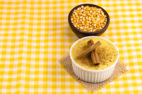 Dessert of curau. Brazilian sweet corn, corn mousse with cinnamon on a wooden background. Typical Brazilian dessert, sweet of June party. Dessert, canjica or Jimbel