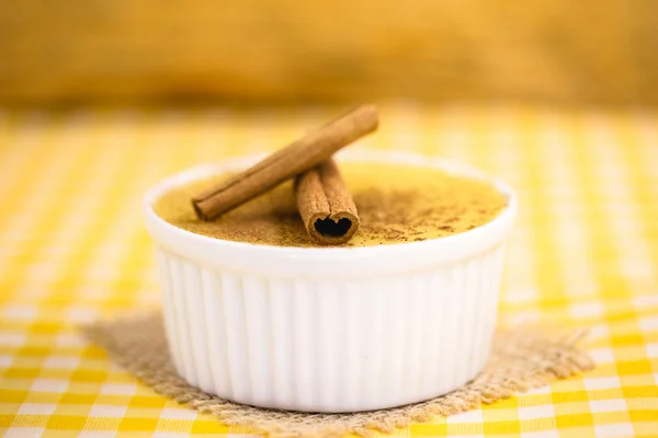 Dessert of curau. Brazilian sweet corn, corn mousse with cinnamon on a wooden background. Typical Brazilian dessert, sweet of June party. Dessert, canjica or Jimbel