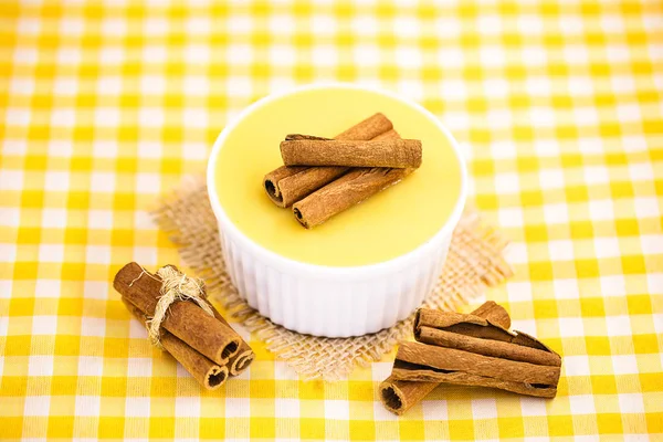 Dessert of curau. Brazilian sweet corn, corn mousse with cinnamon on a wooden background. Typical Brazilian dessert, sweet of June party. Dessert, canjica or Jimbel