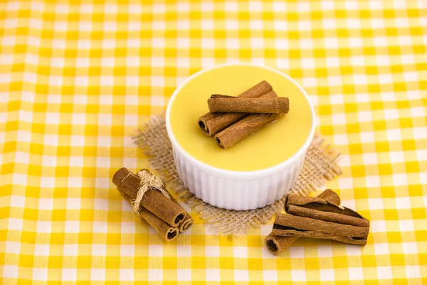 Dessert of curau. Brazilian sweet corn, corn mousse with cinnamon on a wooden background. Typical Brazilian dessert, sweet of June party. Dessert, canjica or Jimbel