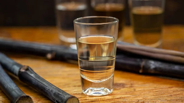 Dos vasos de oro brasileño y cachaca blanca aislados sobre fondo rústico de madera. Bebida típica de Brasil . — Foto de Stock