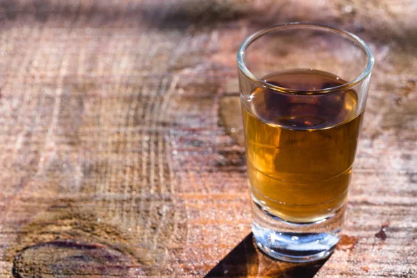 Dois copos de ouro brasileiro e cachaca branca isolados sobre fundo de madeira rústica. Bebida típica do brasil . — Fotografia de Stock