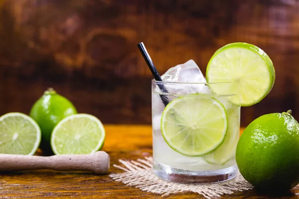 Bevanda tipica brasiliana di nome Caipirinha, a base di limone e zucchero con cacachemigna. Cocktail preferito del Brasile, isolato sulla consistenza del legno . — Foto Stock