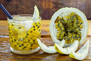 Caipirinha içecek, cachaca ve tutku meyve yapılmış. Brezilya ahşap arka plan geleneksel alkollü içecek. Metin için alan içeren resim.